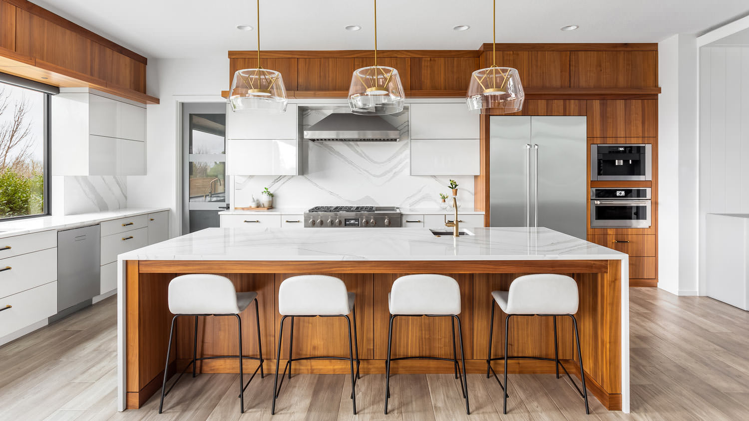 A waterfall kitchen island with pendant lights above it