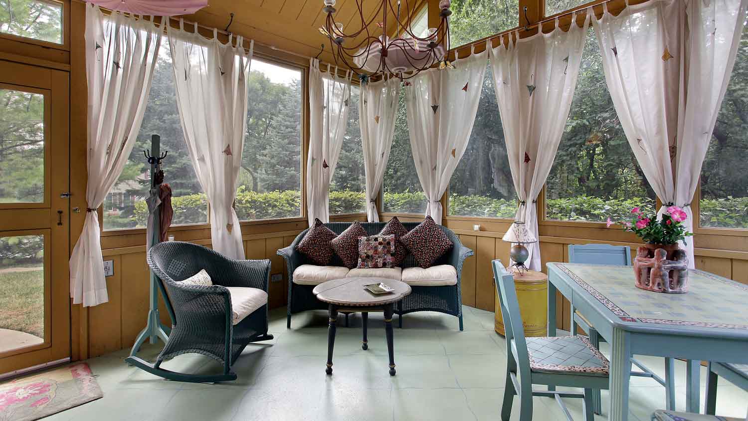 A screened-in porch with curtains