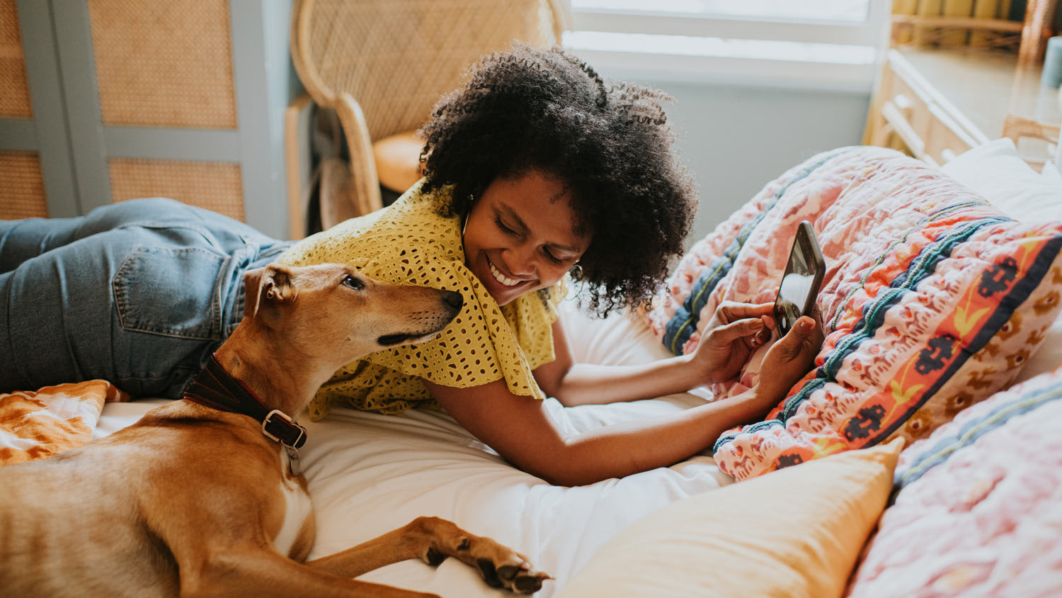 Woman laying in bed with with dog