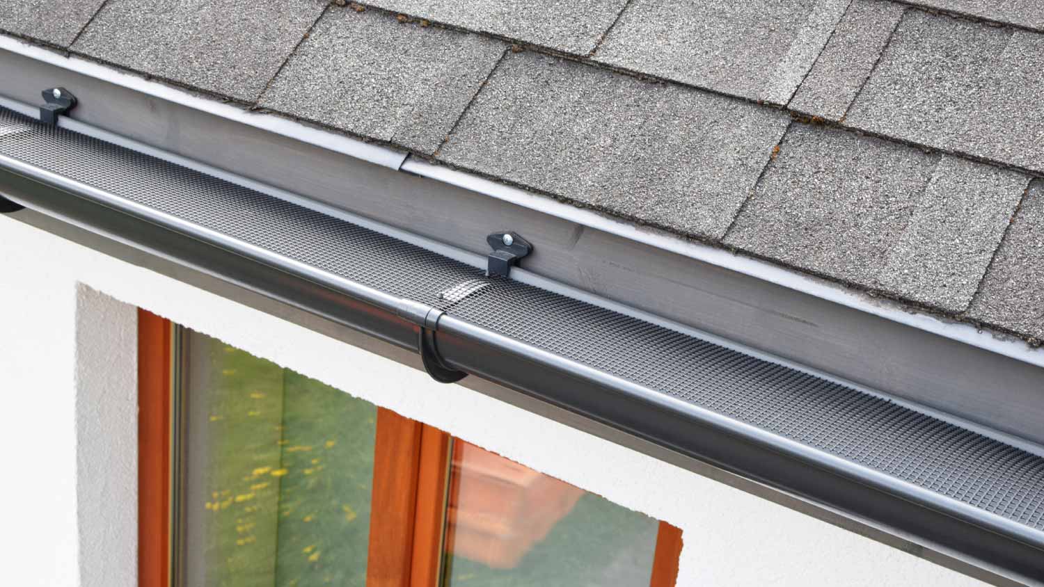Plastic guard over new dark gray plastic rain gutter