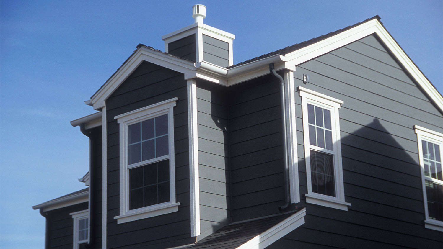 An exterior view of a gray house with white trim