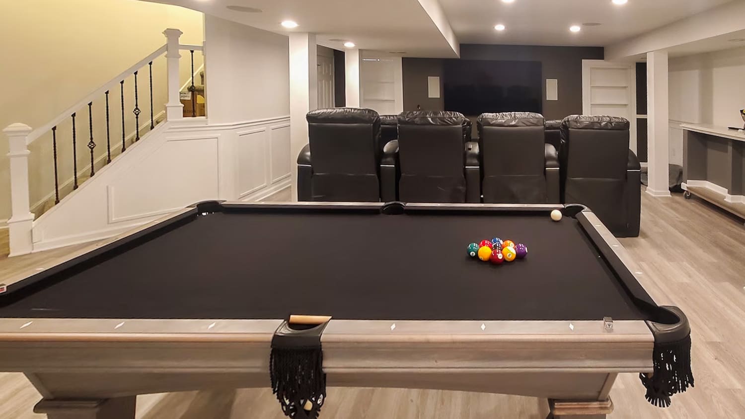 Basement game room with a pool table