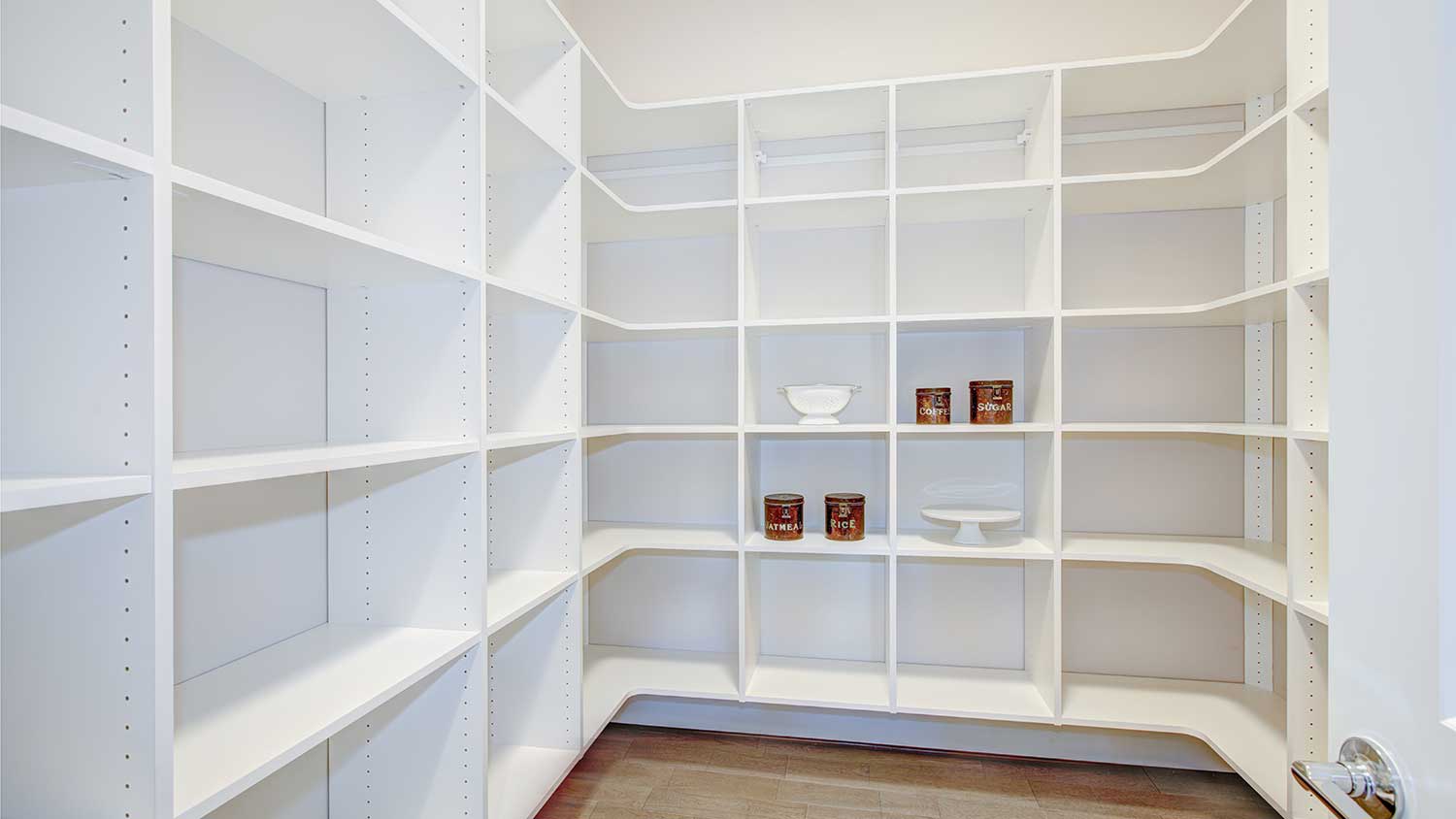 Empty pantry with white built in shelves