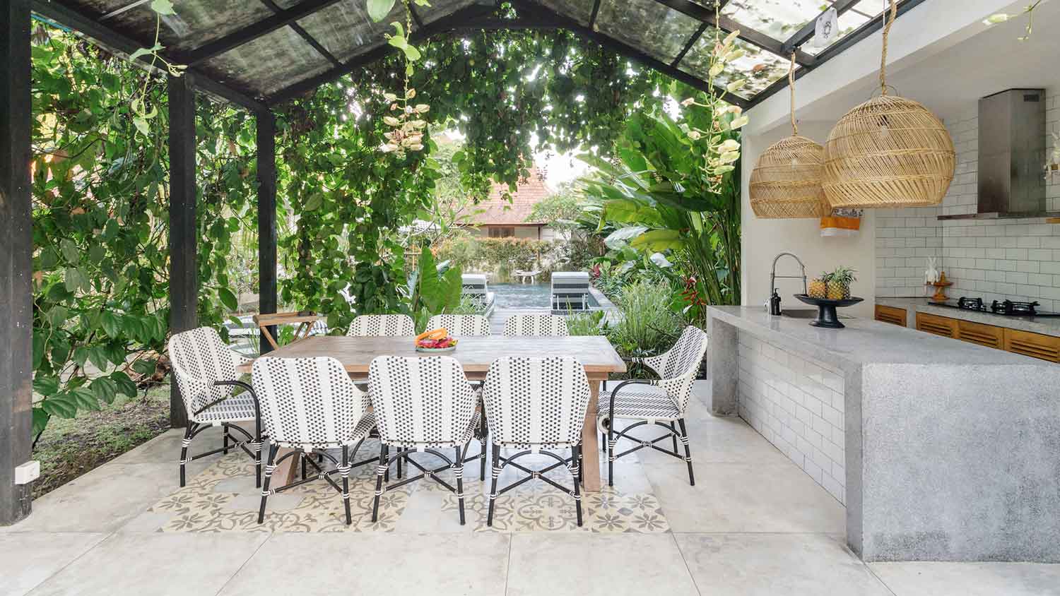 Outdoor kitchen with concrete flooring and dining table