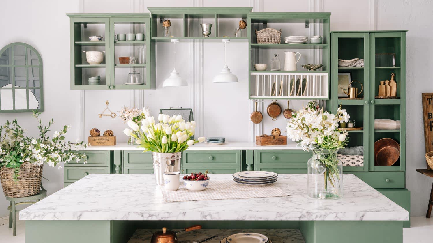 A bright kitchen with green cabinetry