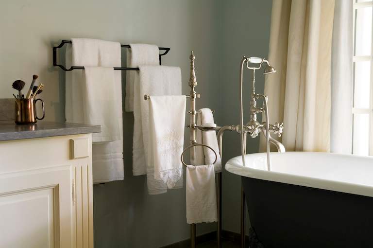 closeup of bathroom with towel racks and freestanding bathrub