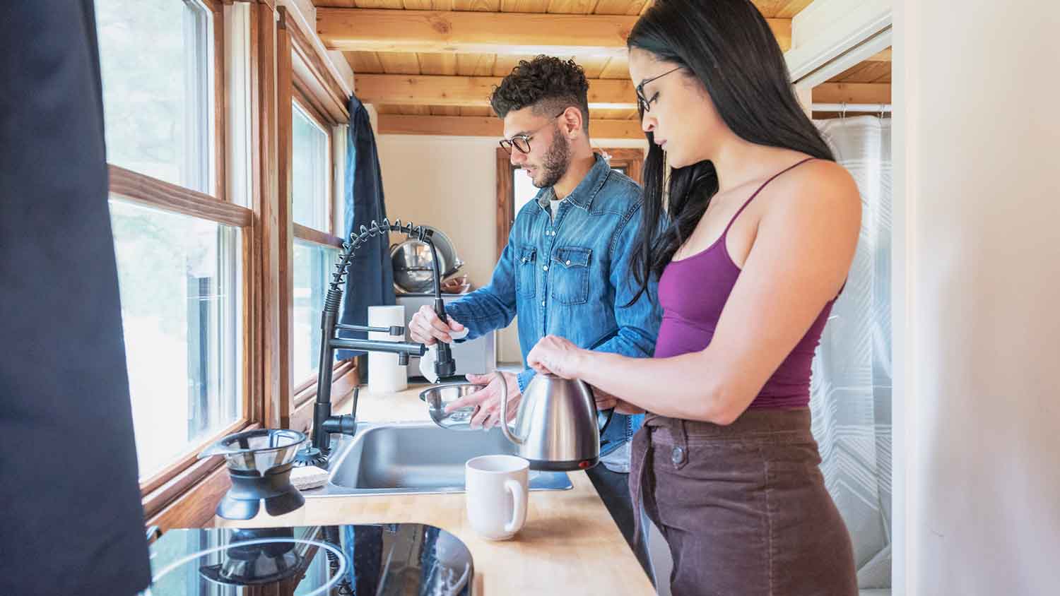 Young couple washing dishes in the kitchenette
