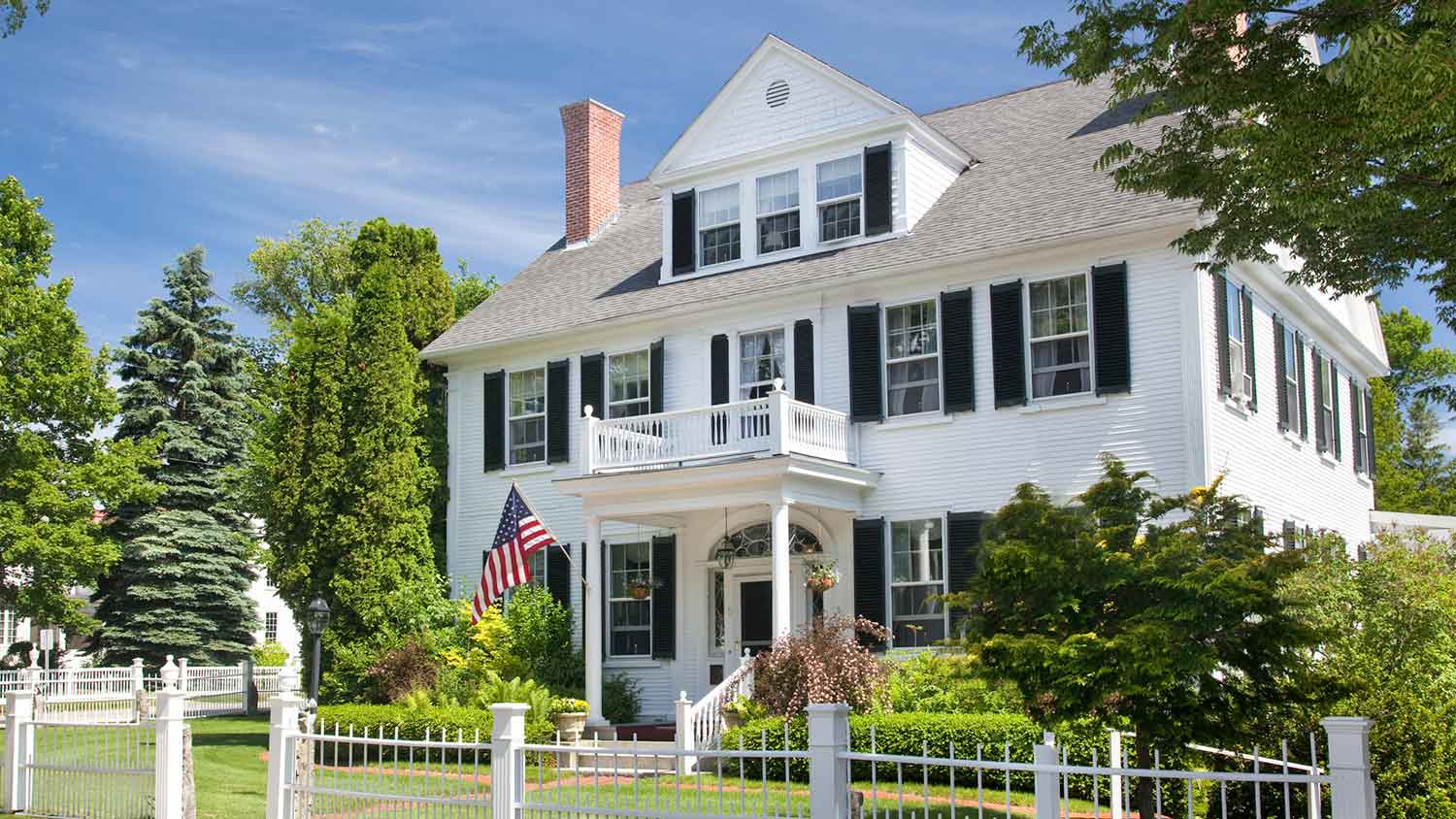 white home with picket fence and black window shutters