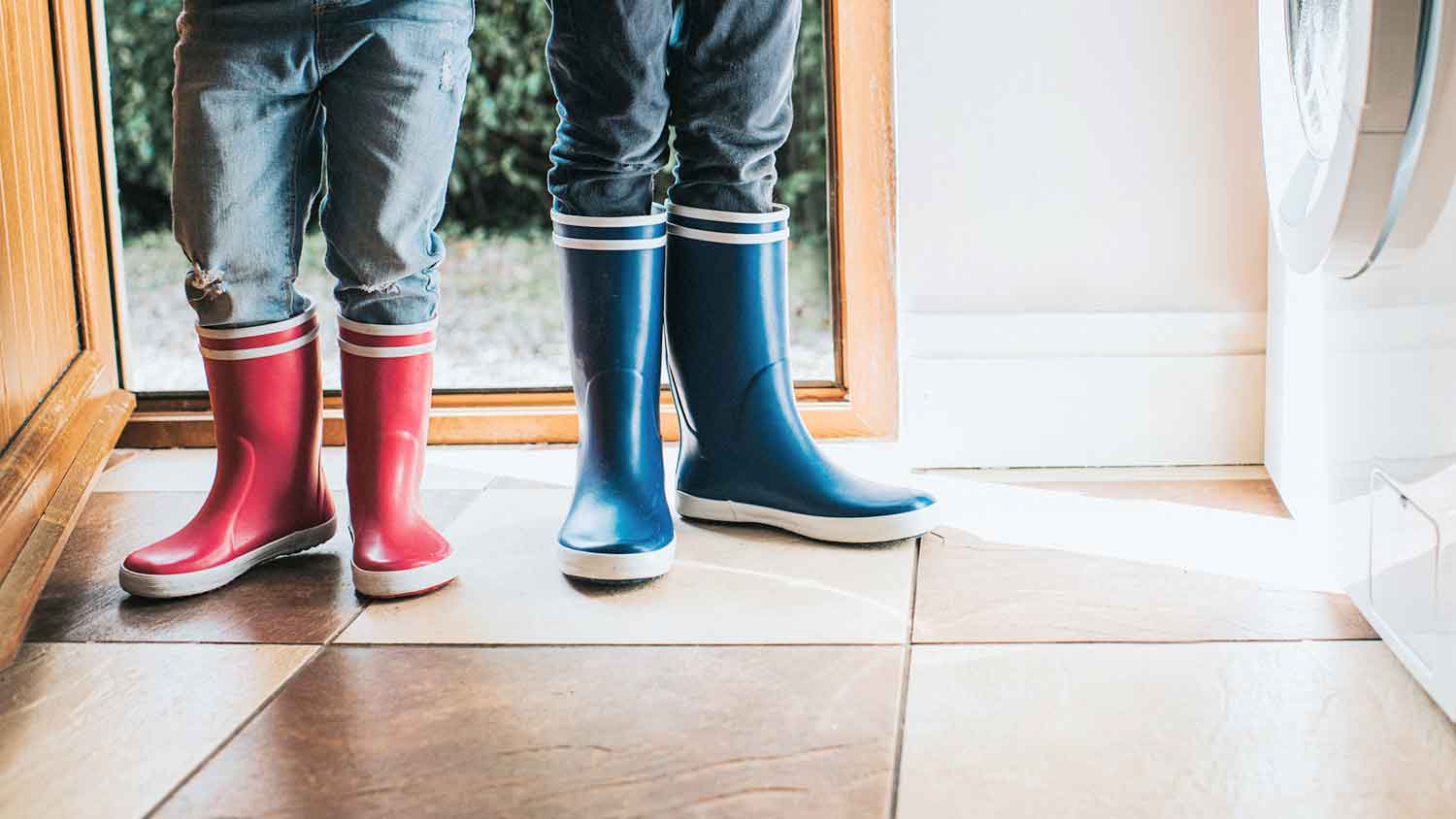 Children in a mudroom wearing rain boots