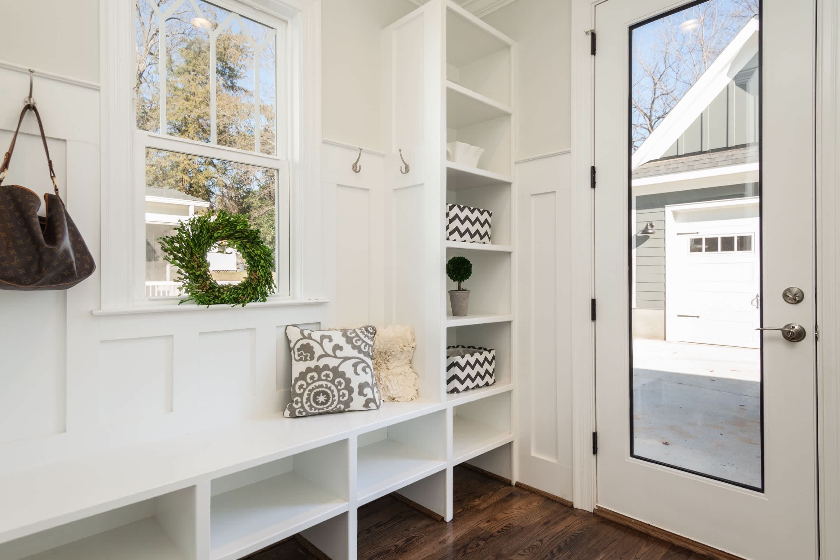 A bright entryway mudroom with a built-in bench and storage