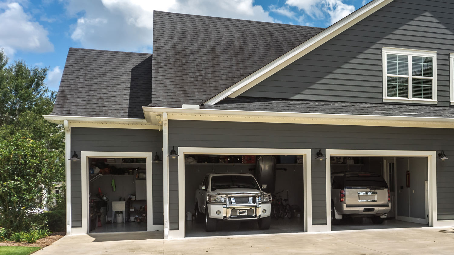 house with a landscaped yard a three car garage and driveway