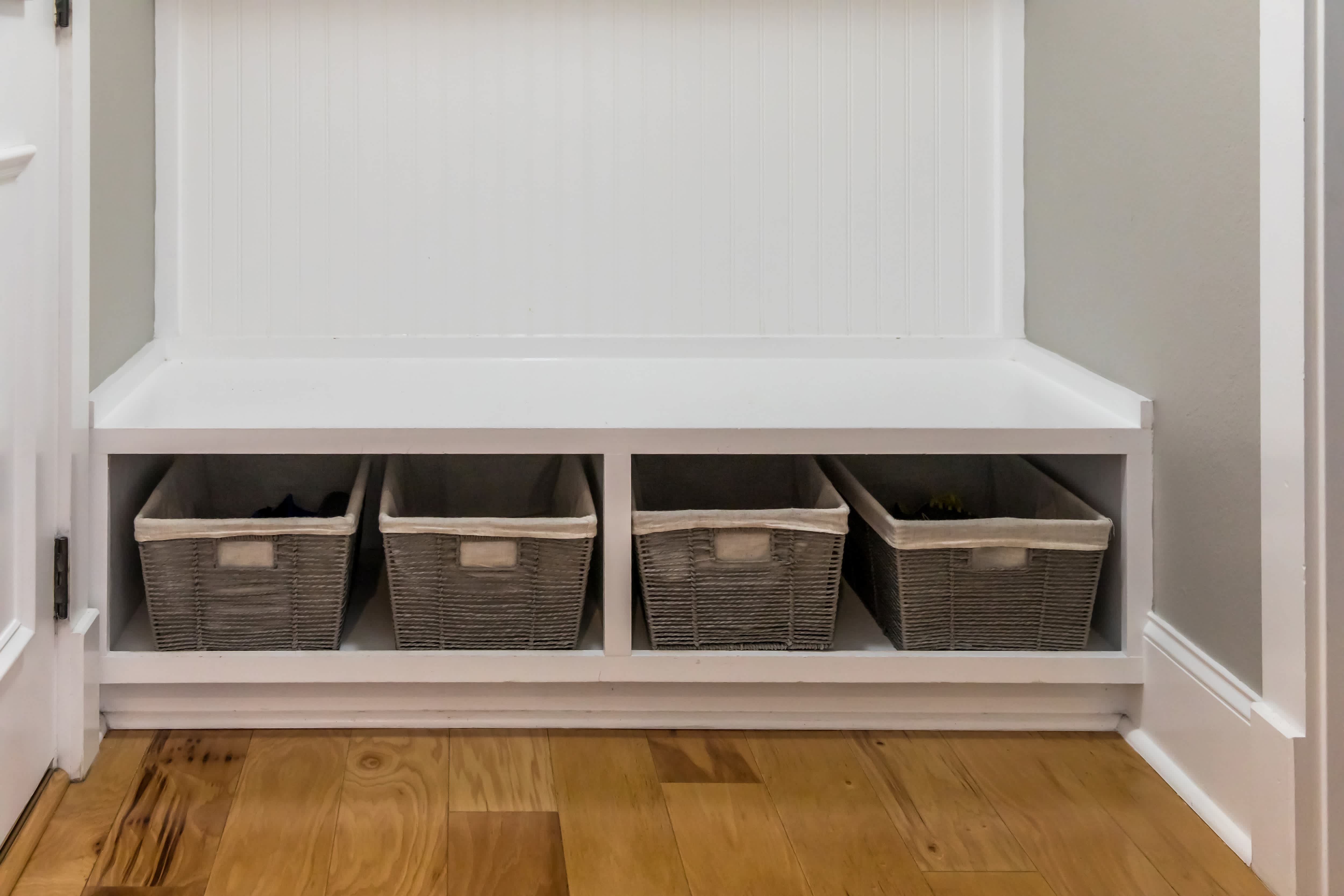 A mudroom with a built-in bench and storage baskets underneath