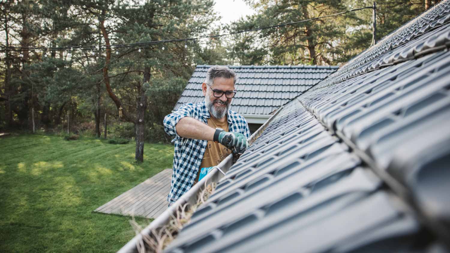 Man cleaning leaves from gutter