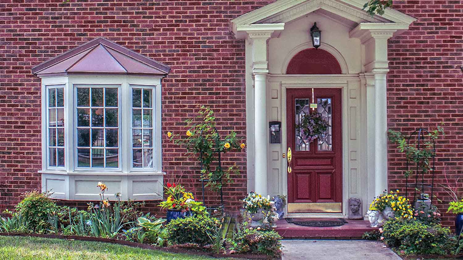 Luxury brick house with bay windows and red front door