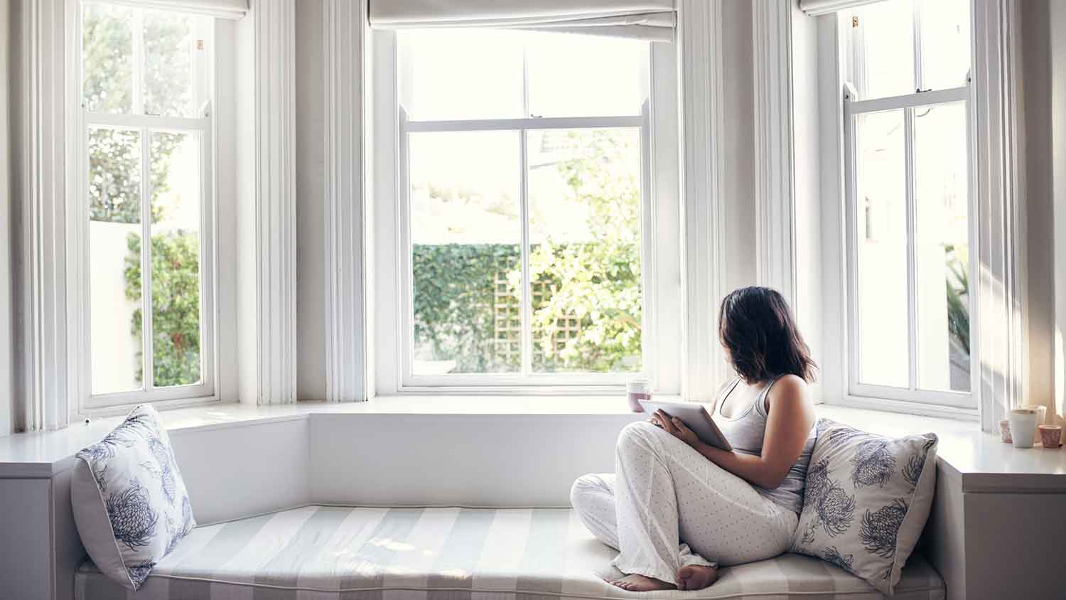 Woman sitting by a bay window