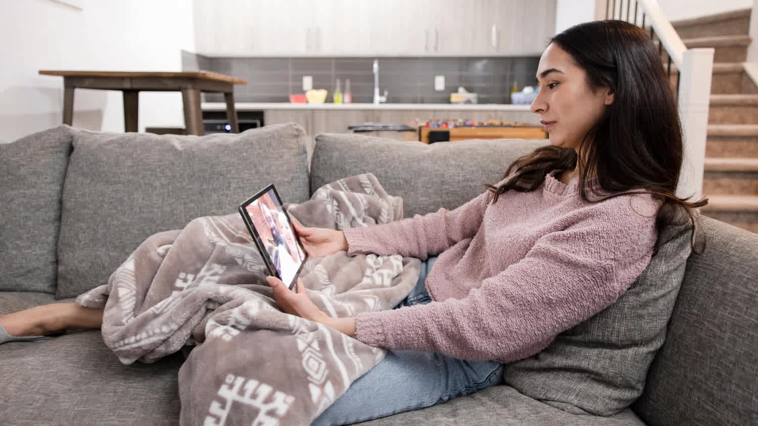 Young woman video chatting with friends on digital tablet screen