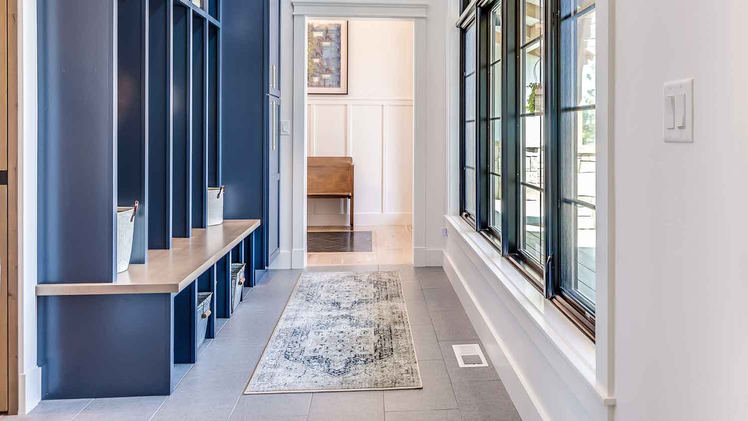Tidy mudroom with area rug and blue lockers
