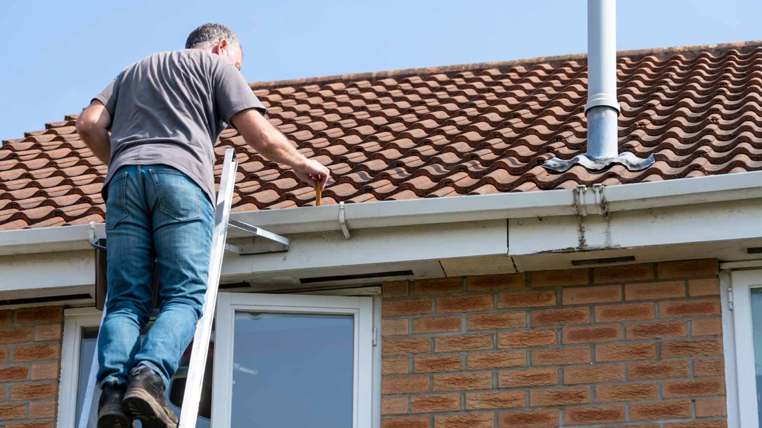 man cleaning gutters