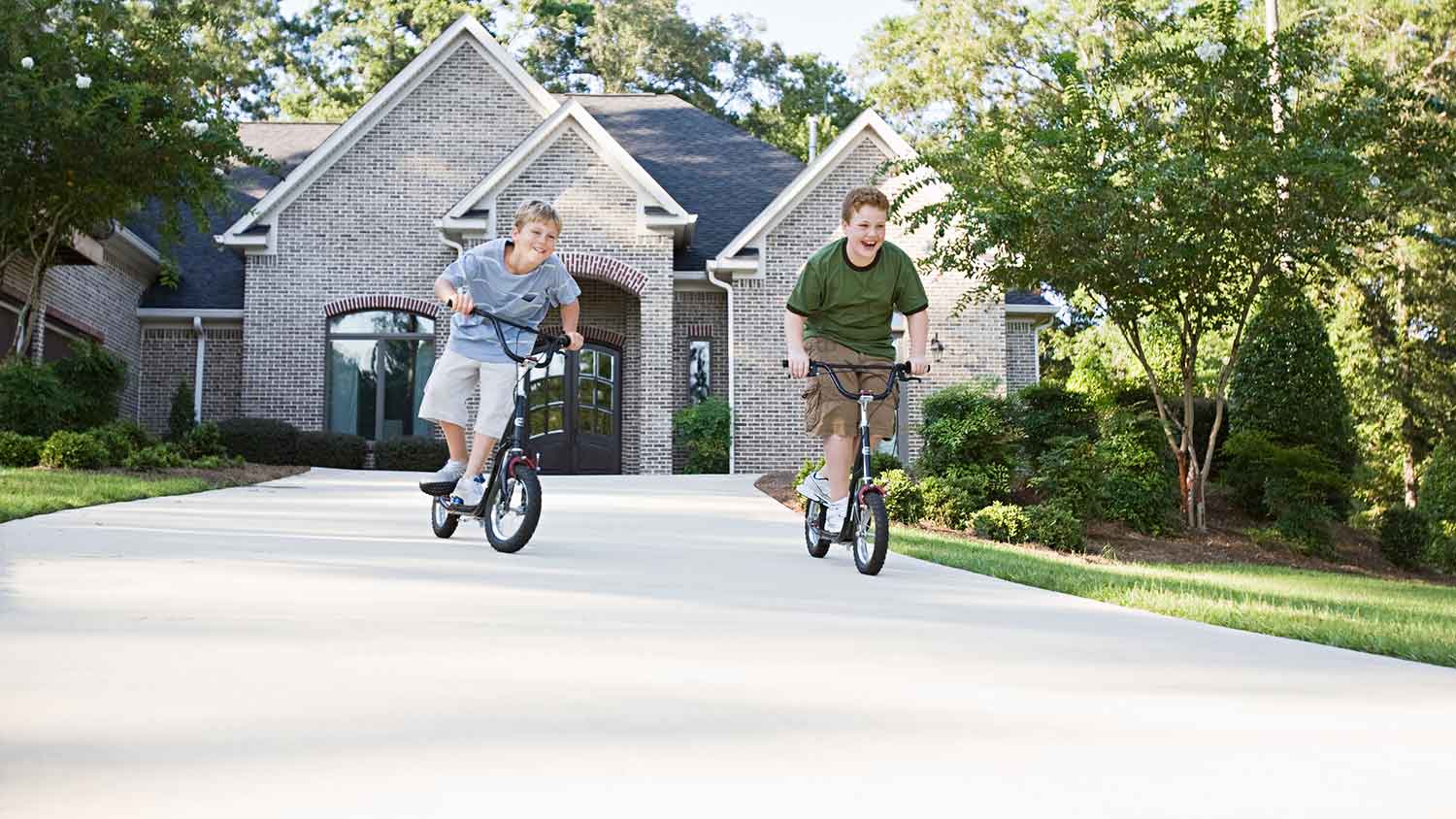 Boys riding bikes in the driveway