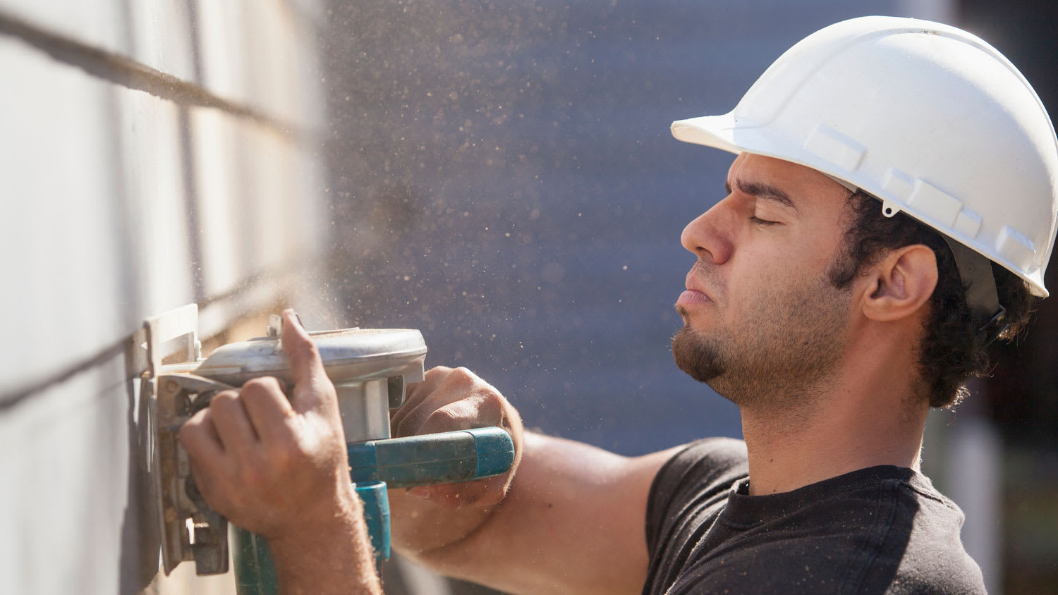 A carpenter repairing the siding on the exterior of a house