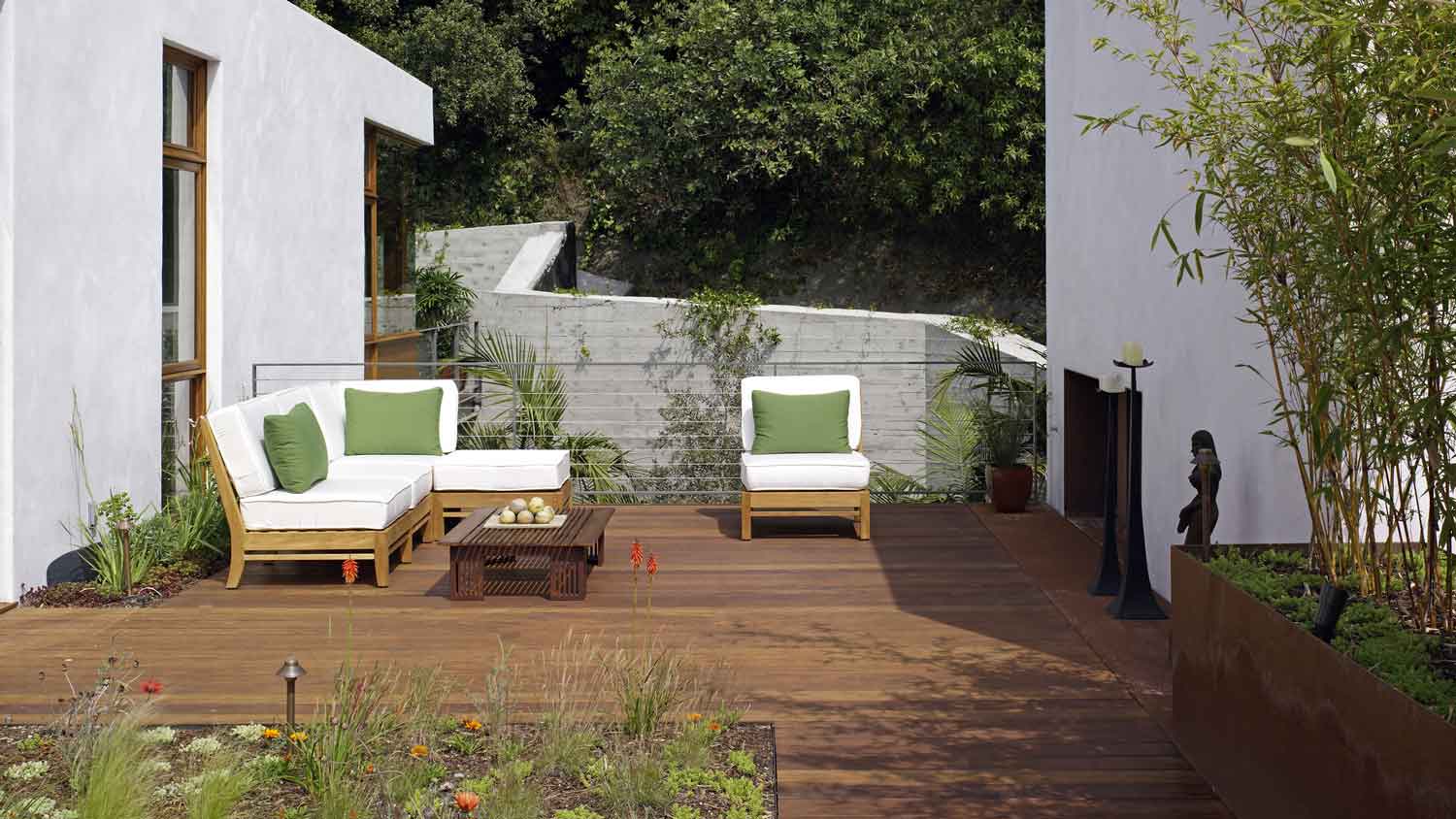 A wooden deck with furniture in a house’s yard