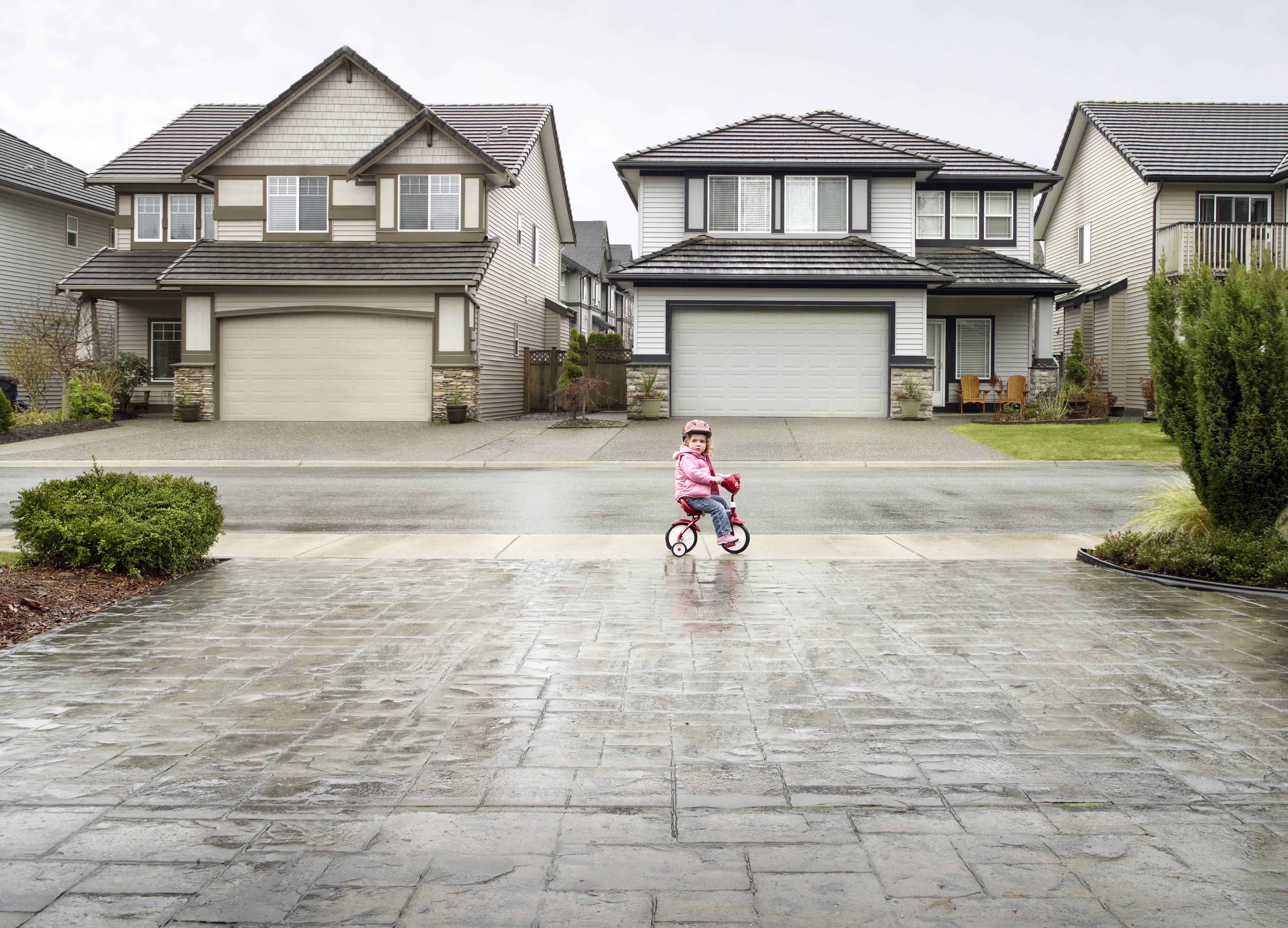 Girl on bike in front of stamped concrete driveway