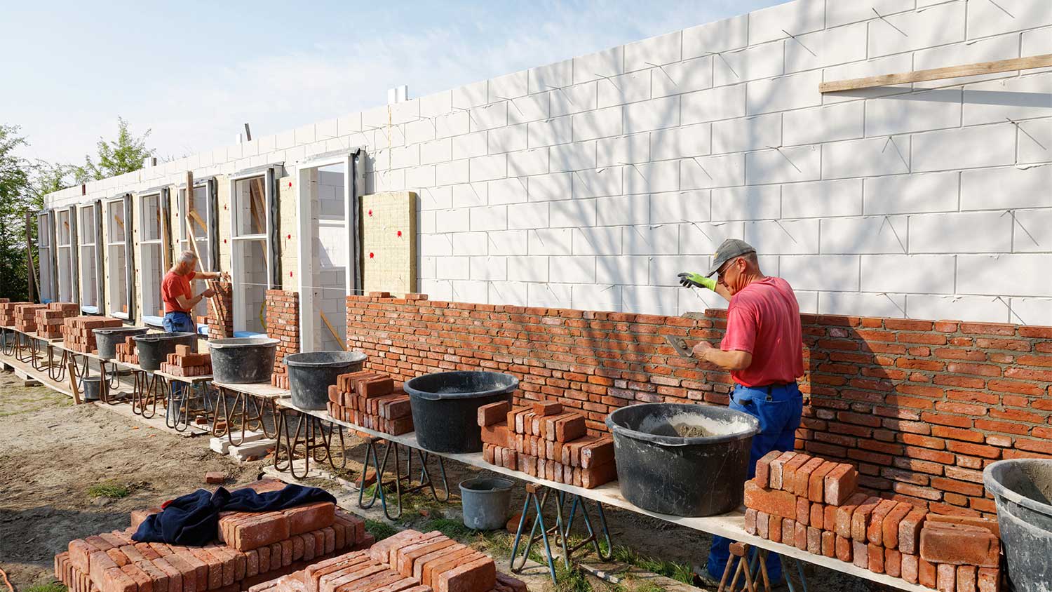 Masons building exterior wall of a house