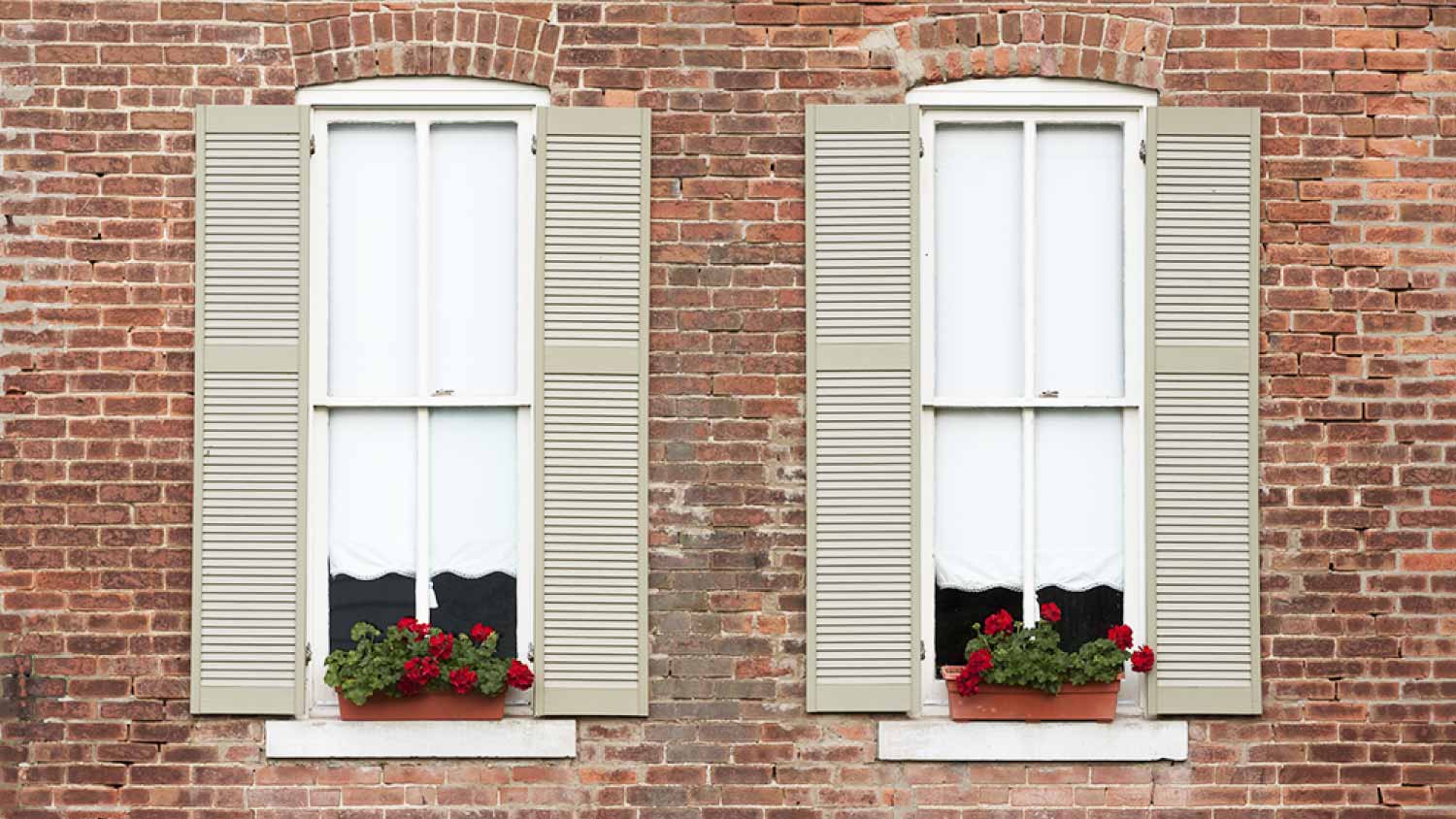 Windows with shutters on old brick home