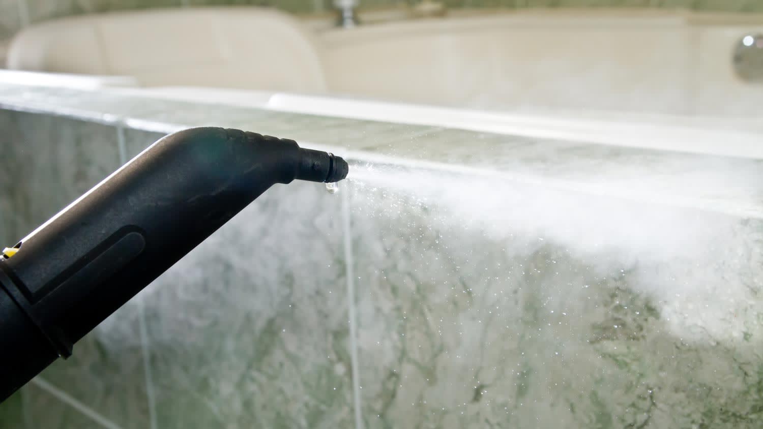 Close-up of pressure washing a bathtub