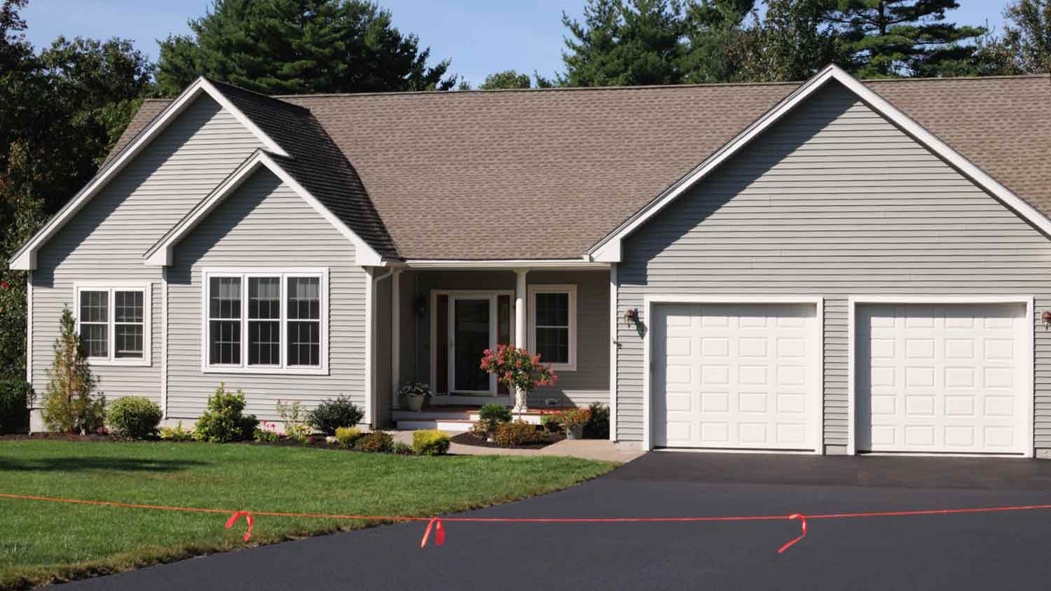 Gray vinyl house with new asphalt driveway