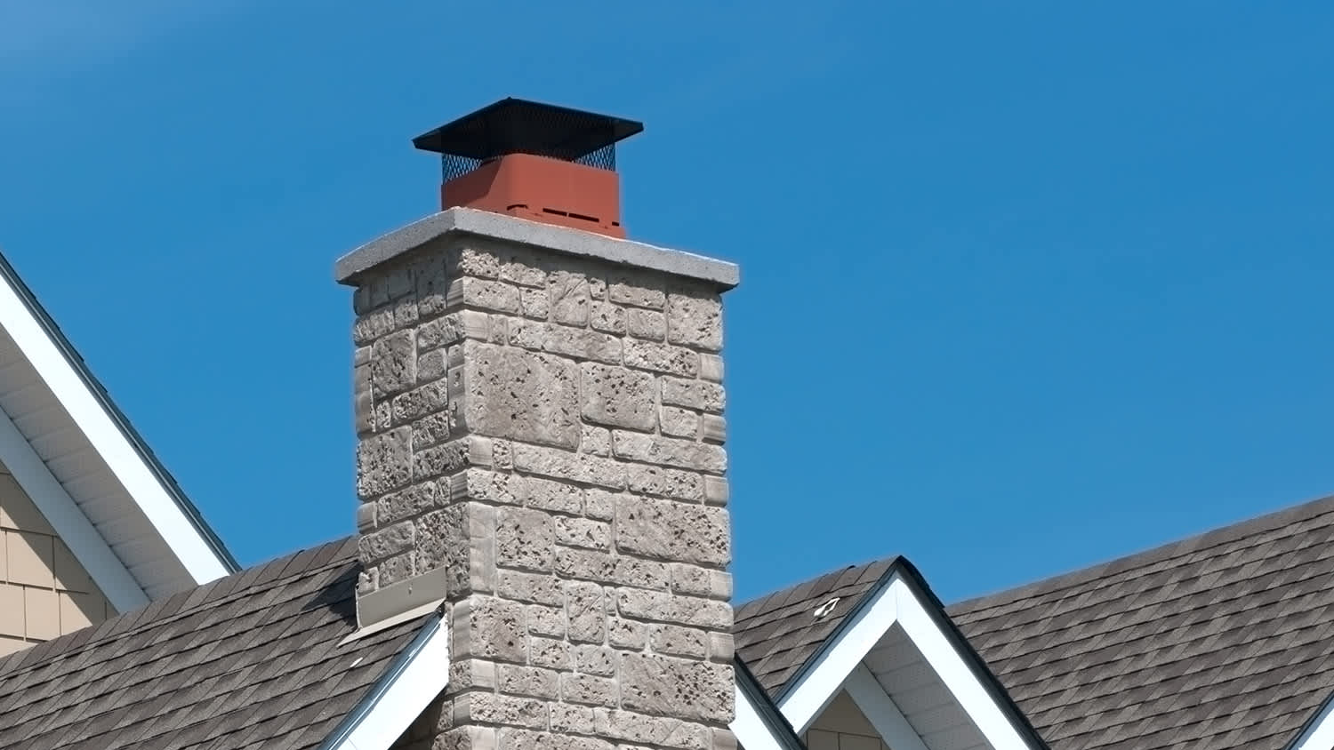 Roof of a house with a stone veneer chimney