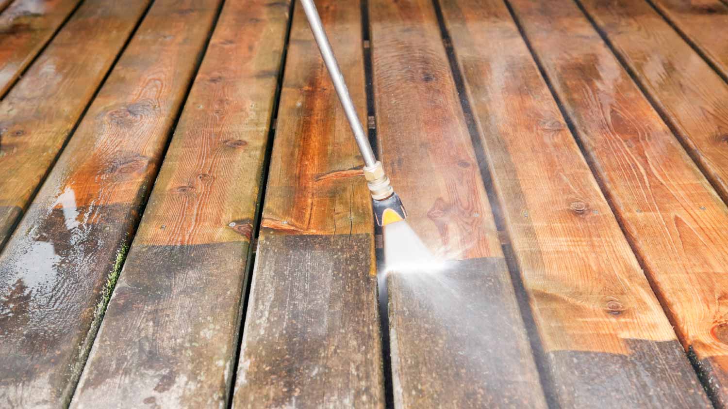 Pressure washer cleaning a deck
