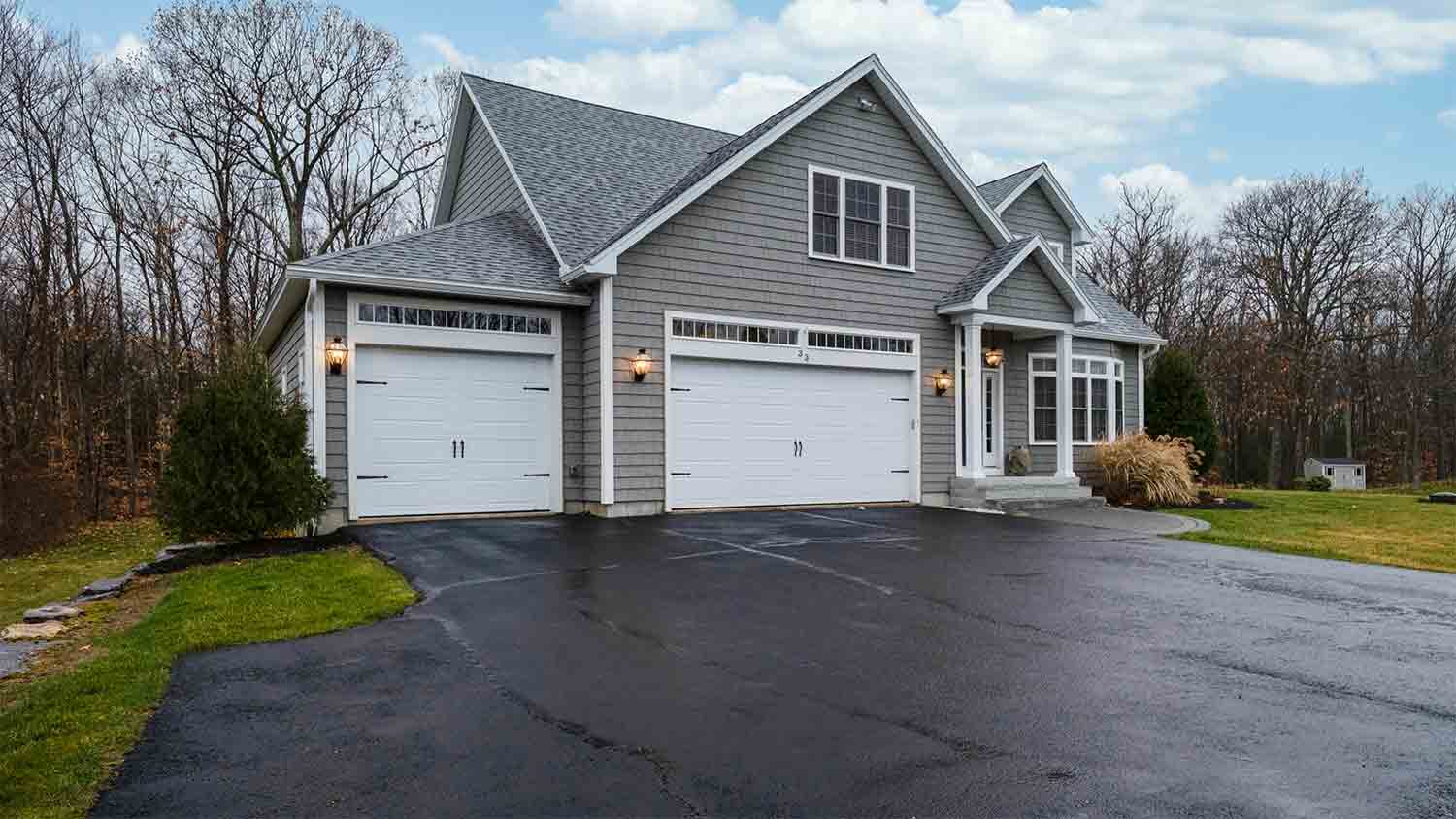 gray suburban house with asphalt driveway