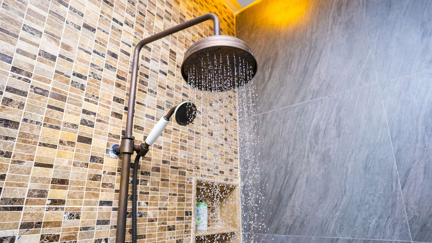 Rain showerhead in tiled shower running water
