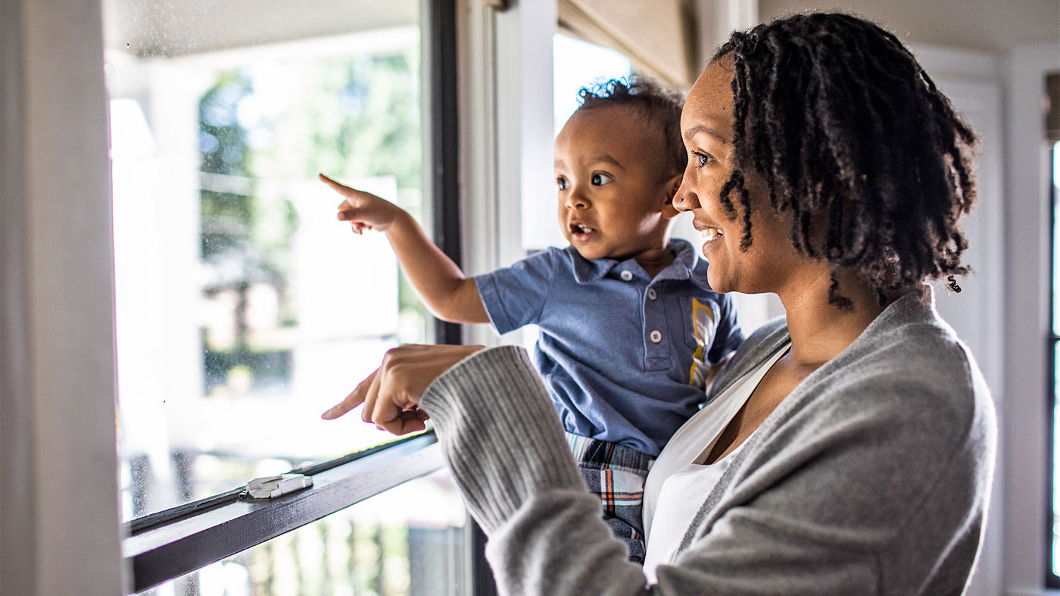 mother and toddler looking out the window
