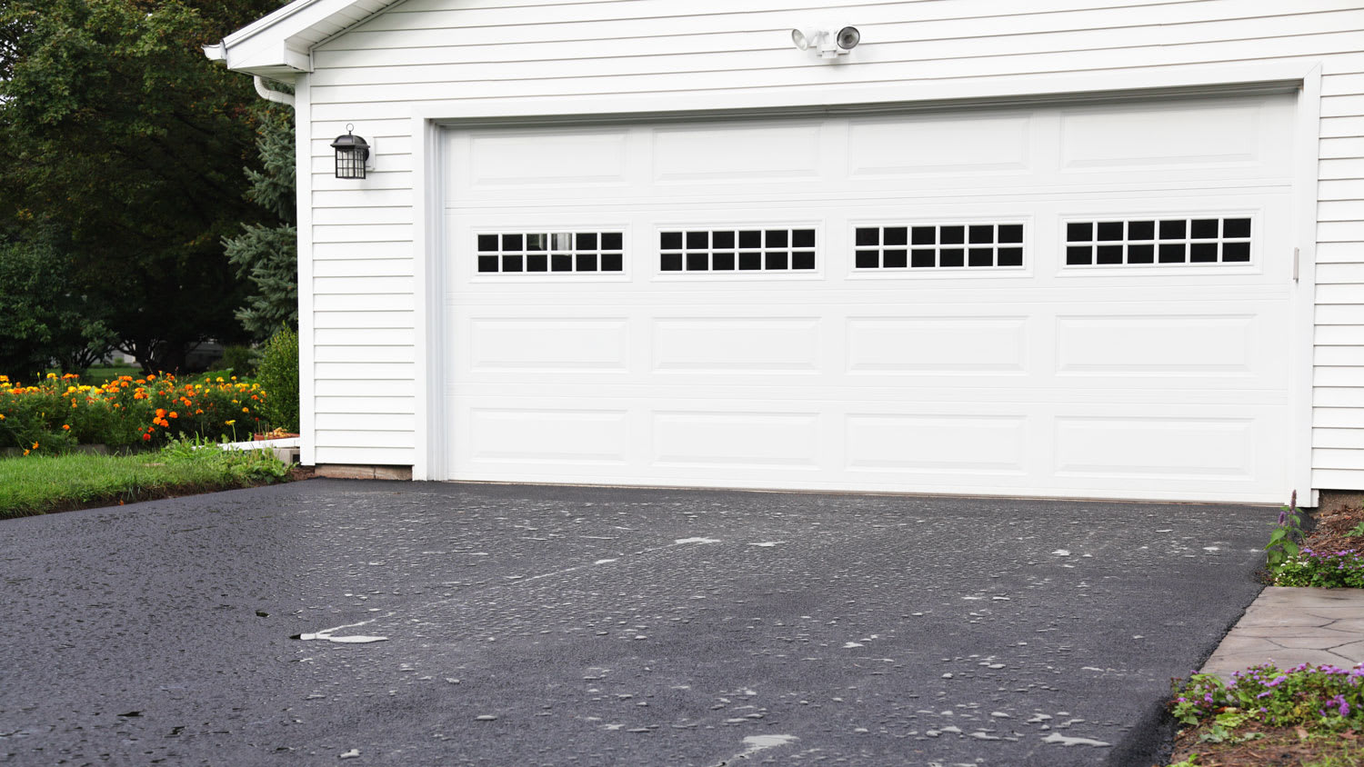 Rain Puddles on New Asphalt Driveway at Residential Home, painted white