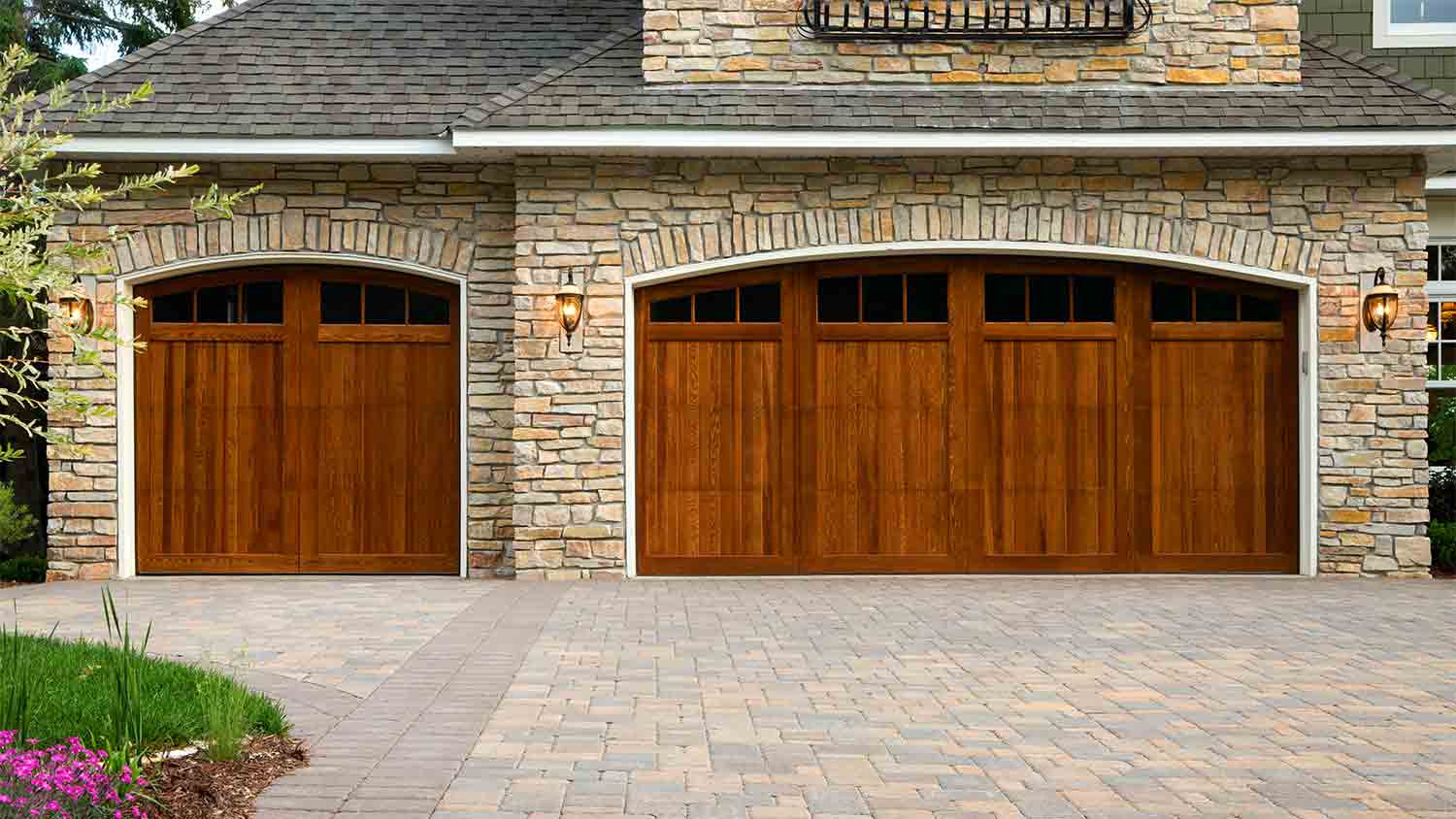 stone home with paver driveway