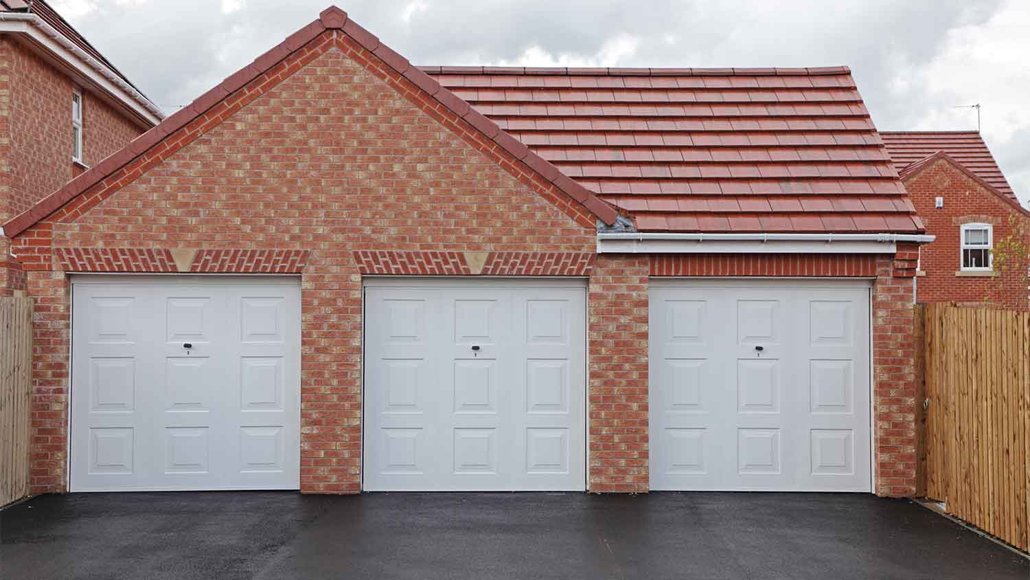 three garages with asphalt driveway