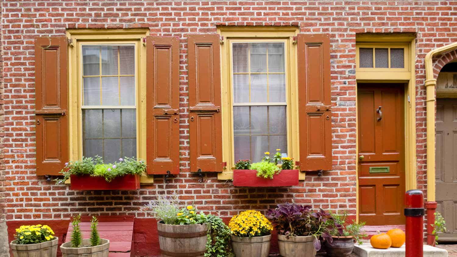 Orange windows shutters on old brick home