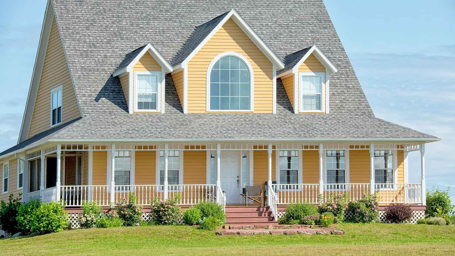 Yellow siding country house with large porch