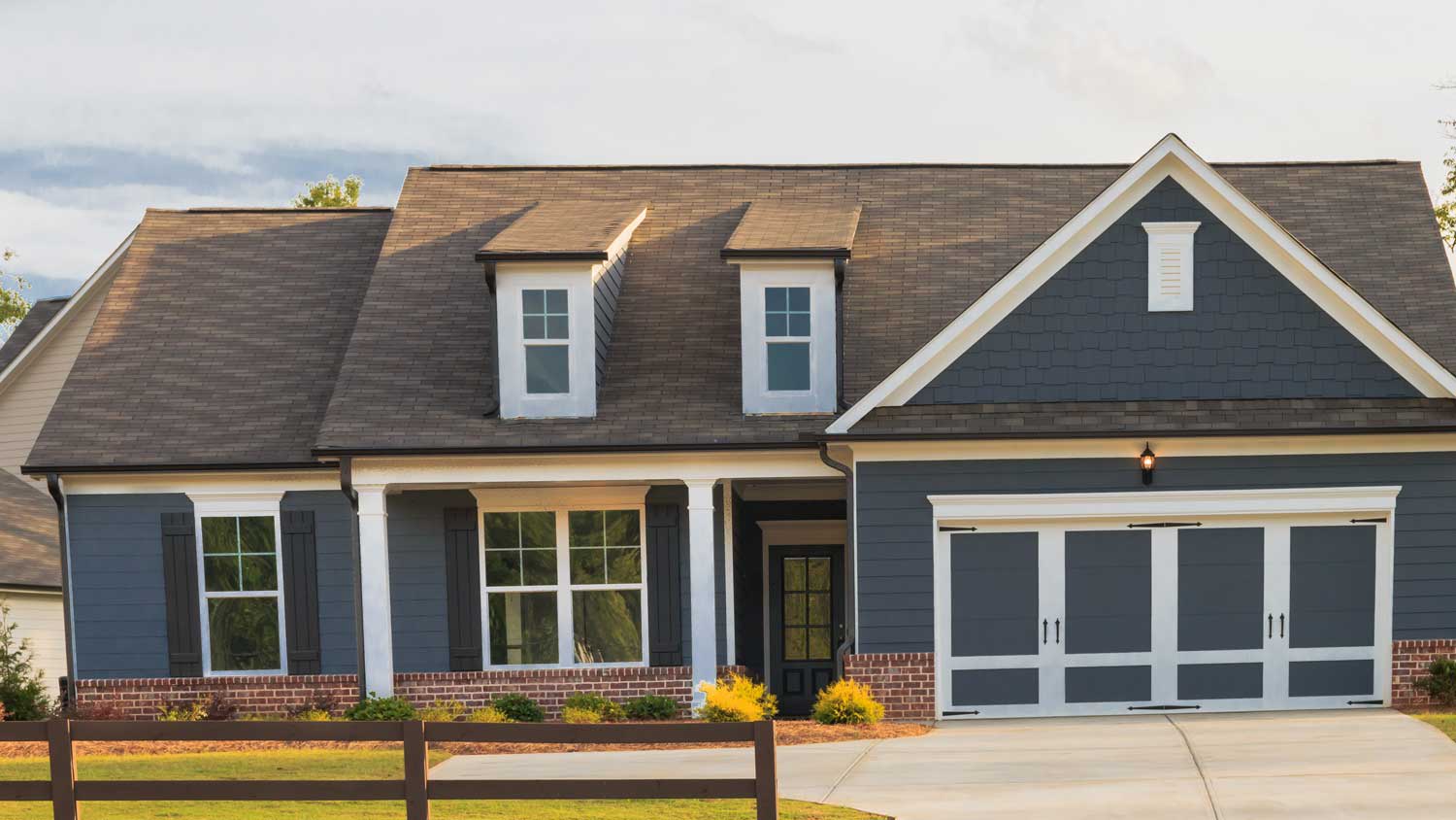 A gray house with brick veneer