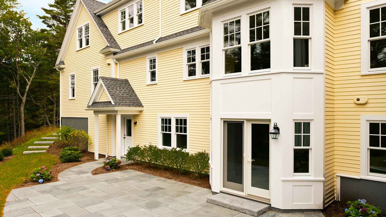 Yellow siding house with backyard patio