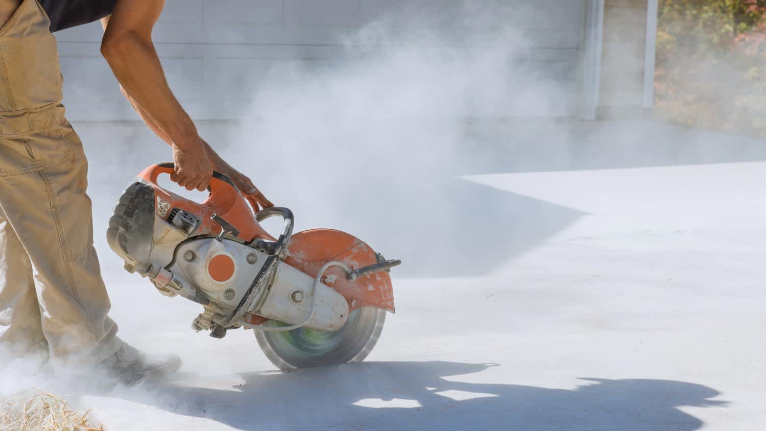 man cutting concrete sidewalk