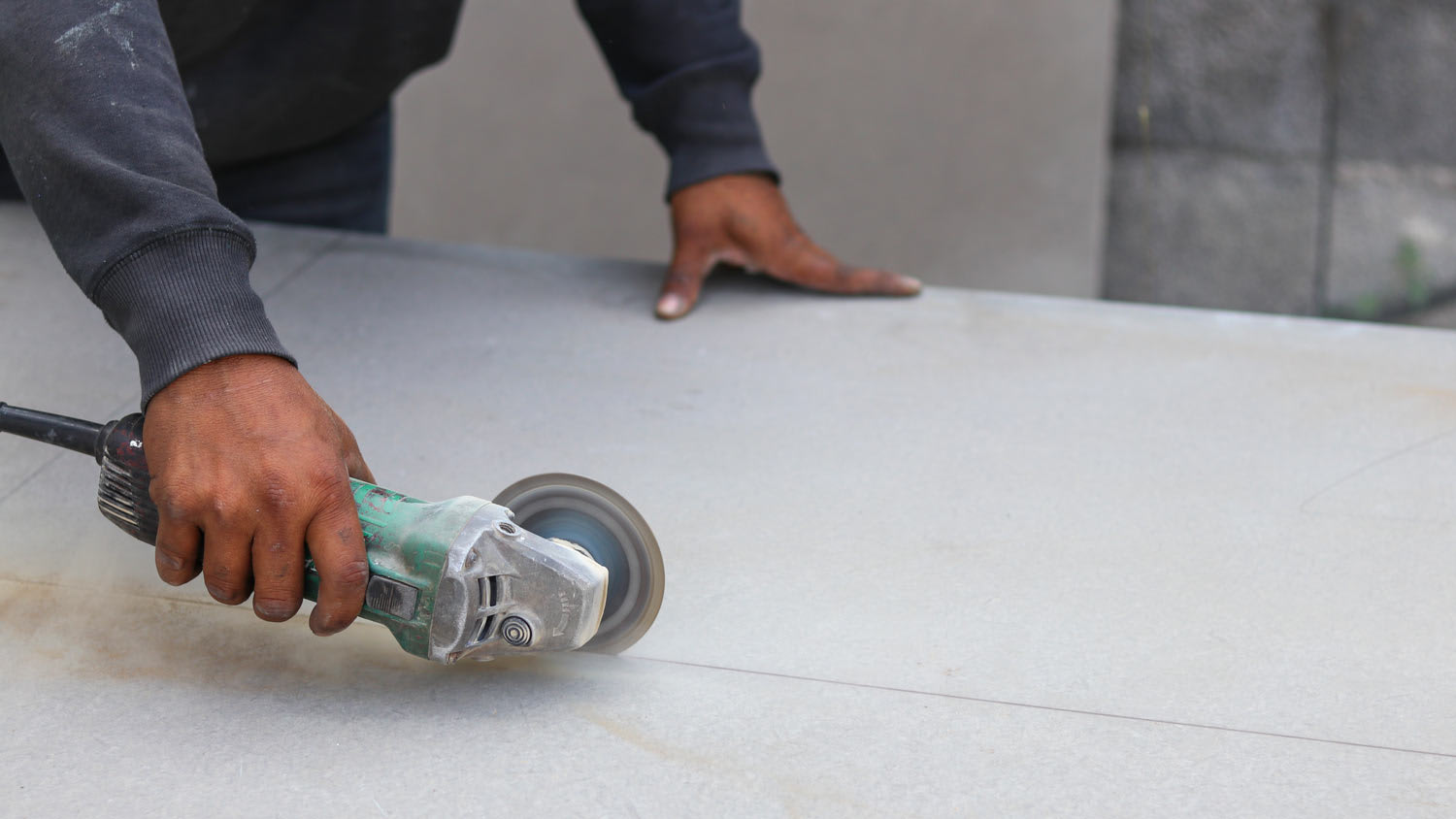 man using grinding machine to cut cement