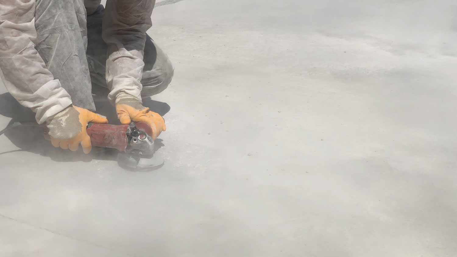 Worker grinding concrete surface