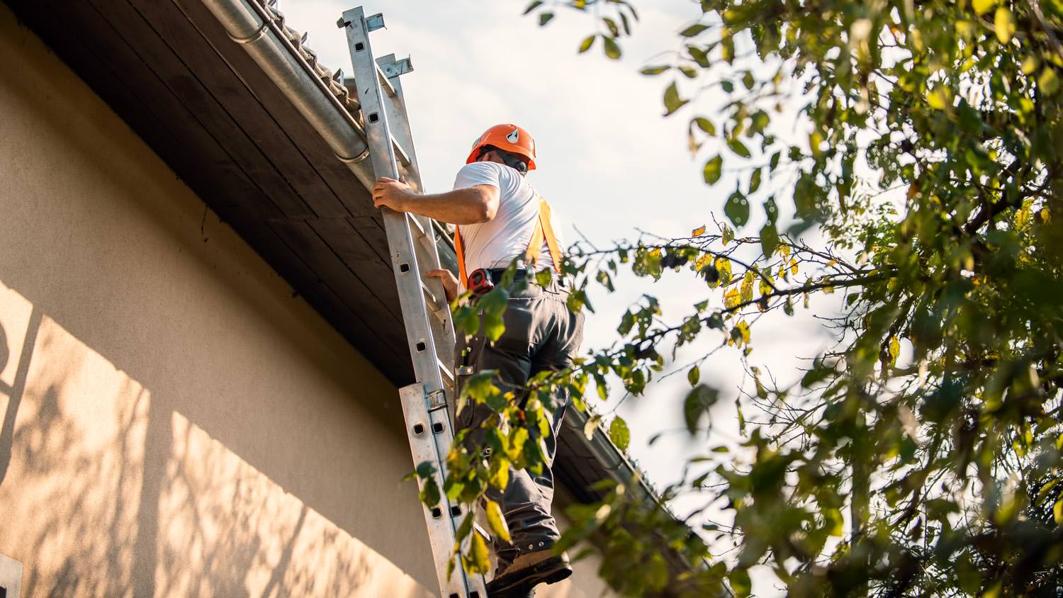 A roofer climbing a ladder
