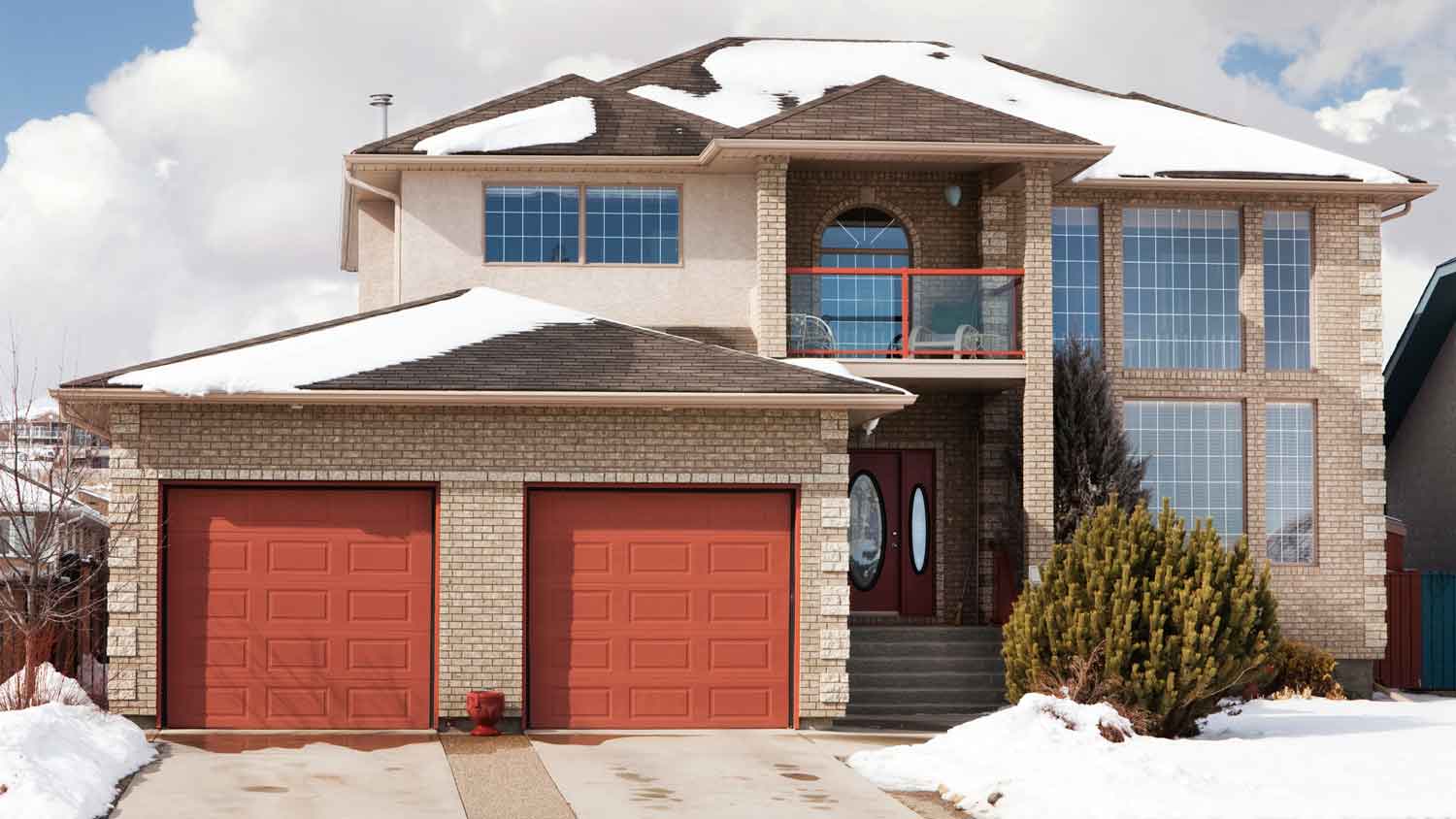 A two-story house with attached garage and clear from snow driveway
