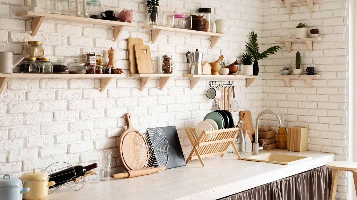 A rustic kitchen with a whitewashed brick wall