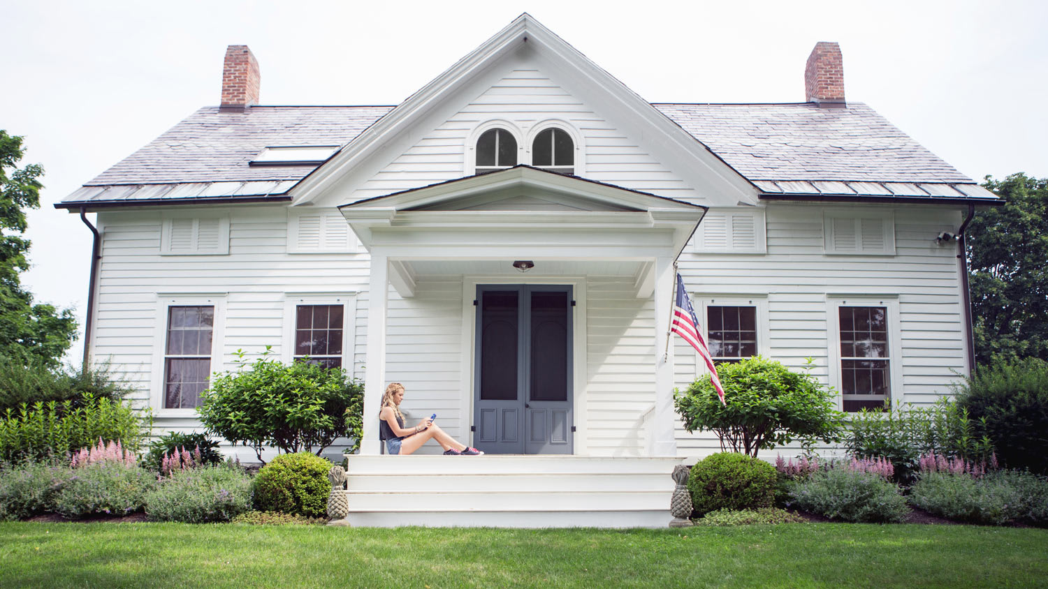 Young woman sitting on front porch