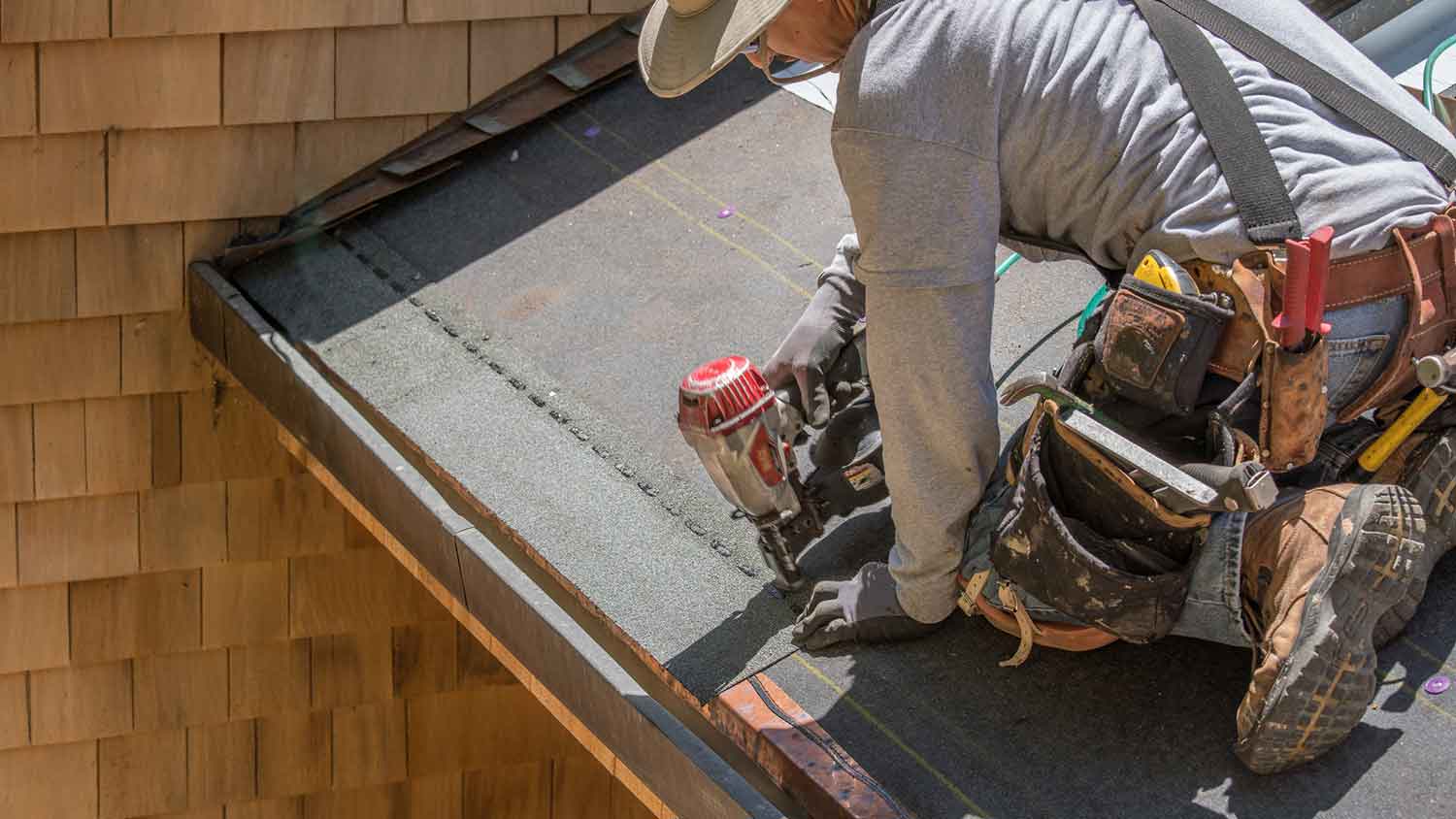 Roofer installing roof underlayment